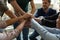 Overjoyed colleagues stack hands engaged in teambuilding activity