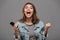 Overjoyed girl in jeans jacket holding mobile phone and showing