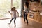 Overjoyed Latino mom and daughter dance at home