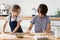 Overjoyed little children siblings playing with flour in kitchen.