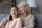 Overjoyed mature mom and adult daughter relax at home