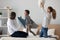 Overjoyed mixed race family of three fighting with pillows.