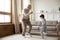 Overjoyed senior grandfather dance with small grandson