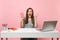 Overjoyed shocked woman screaming spreading hands holding plactic cup with cola or soda work at white desk with pc