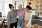 Overjoyed successful diverse businesswomen hugging, standing in modern office