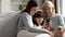 Overjoyed three generations of women laugh watching video on cell