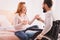 Overjoyed woman drinking tea with her disabled husband