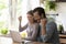 Overjoyed young married couple making yes gesture, looking at computer.