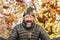 Overjoyed young mature man portrait with fun expression on face and orange yellow leaves background. Trees and nature in autumn