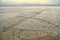 Overlapping, intersecting waves on seashore with dramatic cloudy sky  illuminated by the sun. Natural background, pattern, texture