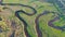 Overlooking a small river among green meadows, a rural landscape near the village, a tree view from above