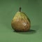 Overly Ripe Comice Pear Isolated on Green Fabric