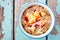 Overnight breakfast oats with peach and coconut on blue wood