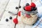 Overnight oats with blueberries and raspberries on a white wood background