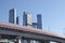 Overpasses on the background of skyscrapers. Blue sky and bright sun. Transport interchanges and urbanism