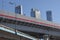 Overpasses on the background of skyscrapers. Blue sky and bright sun. Transport interchanges and urbanism