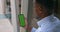 Overshoulder view of afro american businessman holding smartphone in his hand and looking at screen. Concept of green