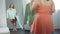 Oversize girl choosing blouse in dressing room at boutique, plus size fashion