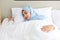 Oversleeping asian muslim woman wearing white sleepwear lying on bed with happiness.Top view portrait young cute girl sleeping