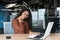 Overtired hispanic woman working in modern office using laptop, businesswoman inside