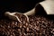 Overturned bag full of coffee beans on black with spatula