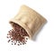 Overturned bag with roasted coffee beans on white background