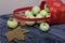 An overturned basket of apples. Nearby are apples and dried maple leaves. Fruit harvest