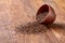 An overturned ceramic bowl with linseeds on a rustic background, close-up, shallow depth of field, selective focus