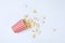 Overturned paper cup with tasty popcorn on white background