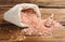 Overturned sack of pink himalayan salt on wooden table