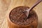 An overturned wooden bowl with linseeds on a rustic background, close-up, shallow depth of field, selective focus