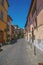 Overview of an alley with old buildings and garage under a sunny blue sky, at Orvieto.