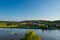 Overview of the bavarian village Sinzing near Regensburg with speed boat cruising on the danube river in golden afternoon light on