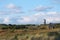 Overview of a Dune Landscsape with a Water Tower and a grazing Inlet Horse