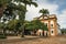 Overview of old colored church, garden with trees and cobblestone street in Paraty.