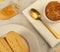 Overview of Orange jam jelly and Italian biscotti with a golden spoon with a white napkin