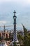 Overview of the Right Pavilion with a Pinnacle, crowned with a Gaudi-typical five-beam cross of the Park Guell in Barcelona, Spain