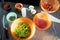 Overview of several bowls with fresh ingredients prepared for vegetable stew and piece of raw meat