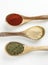 Overview of spices in wooden spoons.