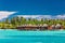 Overwater bungallows in lagoon on tropical island with coconut p