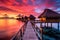 overwater bungalows at sunset with vibrant sky