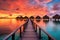 overwater bungalows at sunset with vibrant sky