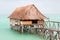 Overwater thatched roof bungalow hut of Micronesian people, lagoon of South Tarawa, heavy rain shower, wet season, Kiribati,