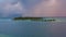 Overwater villas at the time amazing sunset in tropical sea with coral reef. Aerial drone view.