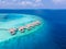 Overwater villas on tropical atoll island for holidays vacation travel and honeymoon. Luxury resort hotel in Maldives or Caribbean