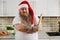 An overweigh man in Santa Claus hat with crossed tattooed arms and a rolling pin on his hand looking at camera thereby showing his