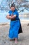 Overweight bearded samurai in blue kimono smiling and training with outstretched hands on sandy river beach