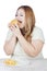 Overweight blonde woman eats burger