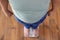 Overweight boy standing on floor scales indoors