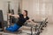 Overweight caucasian woman doing pilates exercises on a reformer.